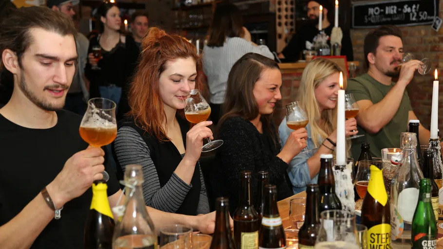 Gruppe von Menschen genießt Bier in einer gemütlichen Bar.