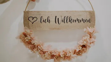 Welcome sign hangs with a flower wreath decoration