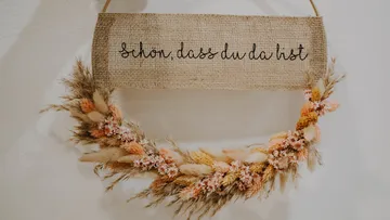 Hanging decoration made of dried flowers with a welcome sign.