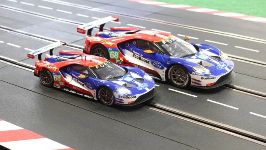 Two model racecars drive on a racetrack.