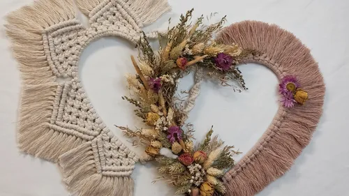 Two heart-shaped macrame designs with flowers.