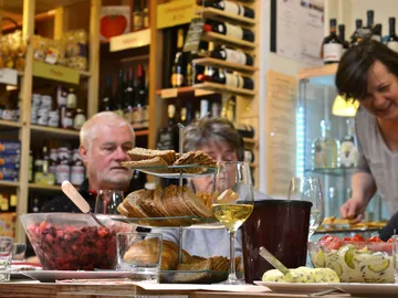 A table with food and drink, people enjoy the meal.