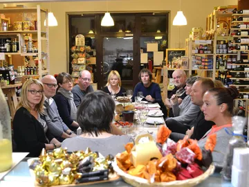 A group of people sit together at the table, surrounded by food.