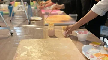 Leute, die in der Werkstatt Leinwände mit Pinseln bemalen.