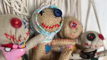 Four handmade dolls hang decoratively; each is individually designed.