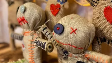 Rag dolls stand with embroideries in a decoration.