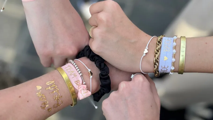 Five hands with colorful bracelets show friendship and togetherness.