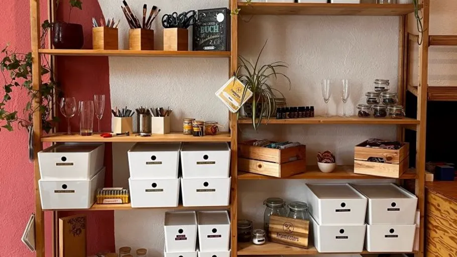 Shelf with containers and office supplies in a room.