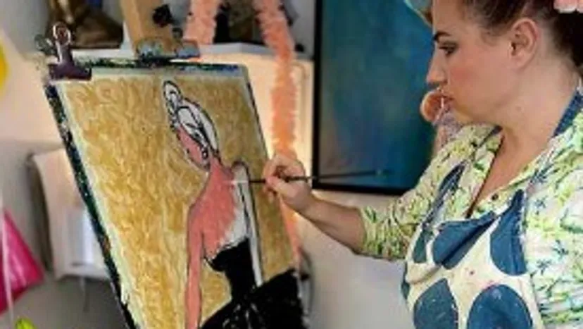 Artist paints on canvas in a studio.