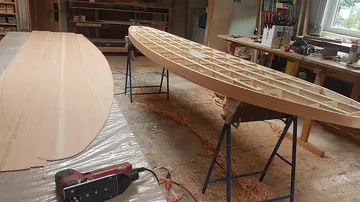 Holzboote werden in einer Werkstatt bearbeitet, umgebaut.