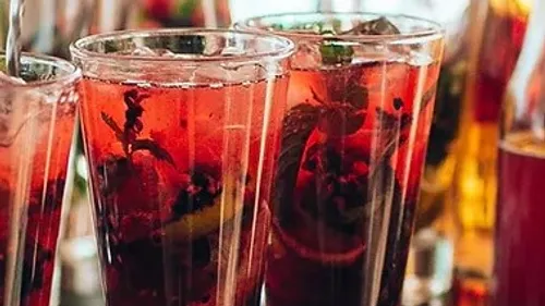 Glasses of red drink are on a table.