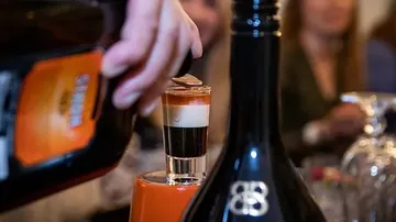 Ein Glas wird mit einem Getränk gefüllt, Umgebung leuchtet.