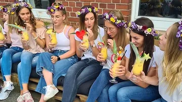Group of women drinking cocktails and laughing.