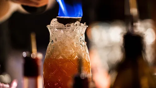 bottle with ice, burning contents, bar-like environment.