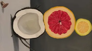 Kokosnuss und Zitrusfrüchte liegen auf einem Tisch.