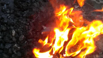 Flames dance over piles of black coal.