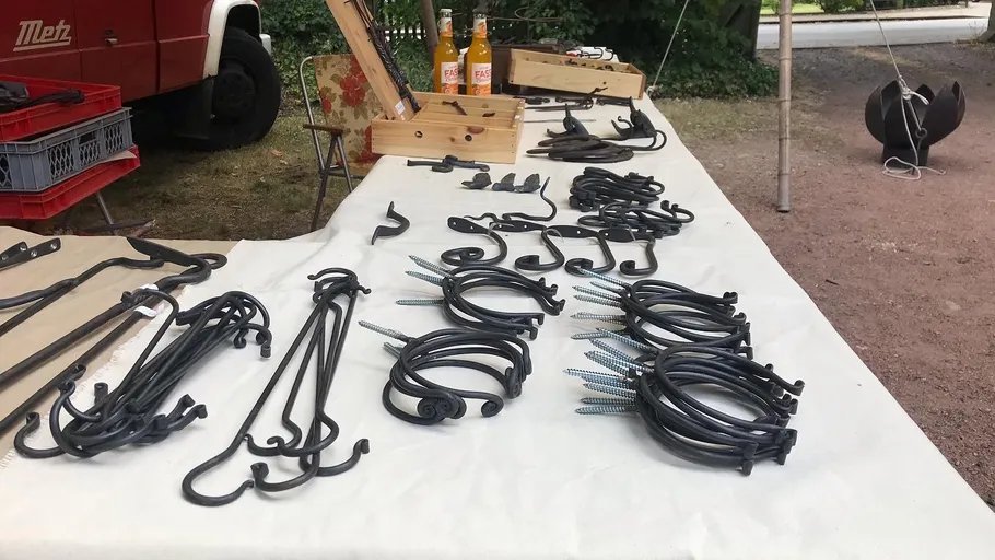 Eisenhaken liegen auf einem Tisch, umgeben von Natur.