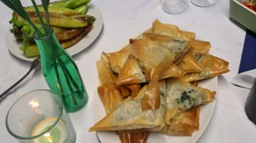 Pasta is laid out on a plate surrounded by side dishes.