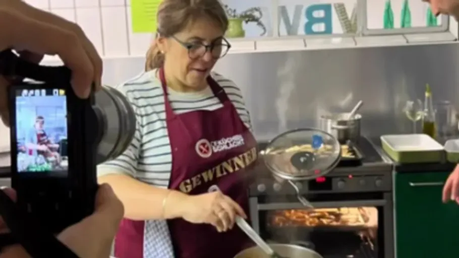 Woman is stirring in a pot in a bright kitchen.