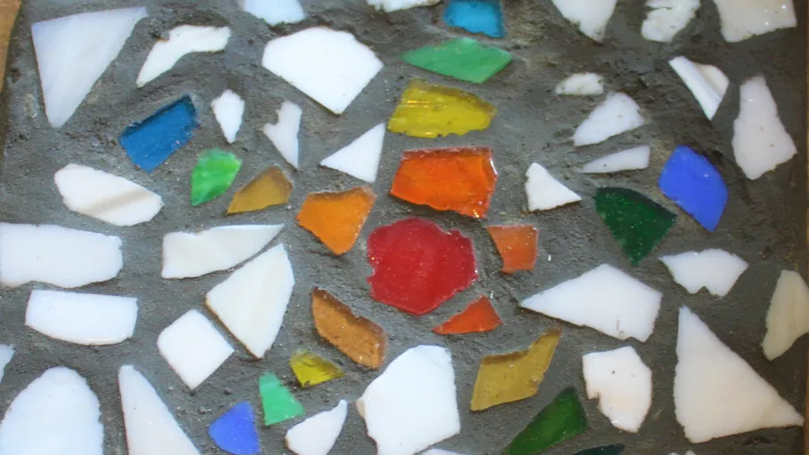 Colorful mosaic tile pieces in concrete.