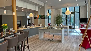 Moderne Küche mit Arbeitsflächen, Essbereichen und großen Fenstern.