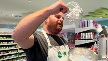 Mann schlägt Eiweiß in einem Geschäft mit Produkten.
