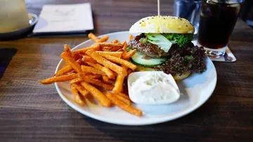 Burger und Süßkartoffelpommes auf einem Teller serviert.