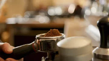 Coffee powder in a portafilter prepared in a coffee environment.