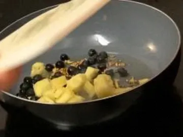 Fruits are swirled in a pan with a lid.