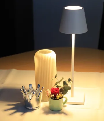 Lamp lights; vases and decorative objects on table.