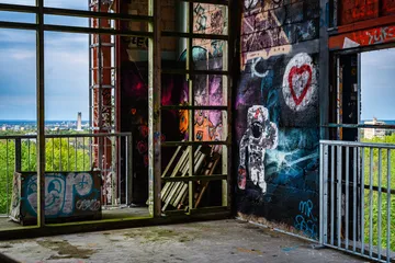 Verlassene Innenräume mit Graffiti und Aussicht auf die Stadt.
