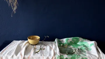 The bowl and objects lie on a decorative cloth.