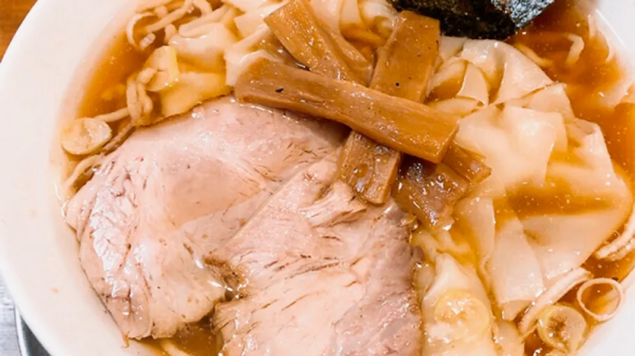 Eine Schüssel Ramen mit Fleisch und Gemüse in Brühe.