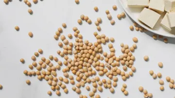 Soybeans are scattered next to cubes of tofu.