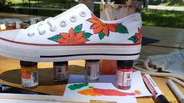 White shoe with flowers painted on an outdoor table.