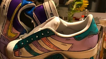 Colourful sneakers are layered on top of each other in a decorative setting.