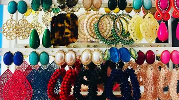 Jewellery is neatly hung on a shelf in different colours.
