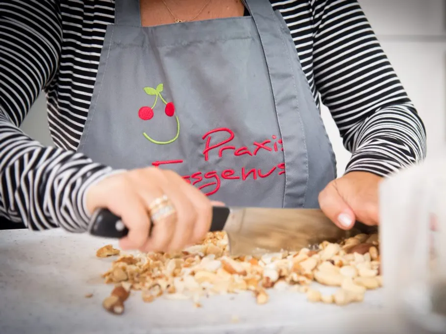 A person is chopping nuts on a table top.