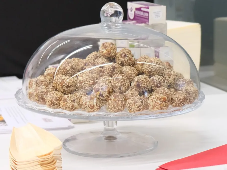A glass bell with sesame balls on a table.