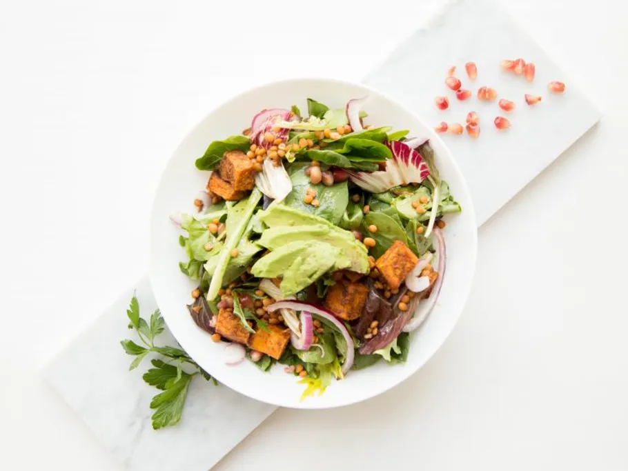 Salad with vegetables, quinoa and avocado in a bowl.