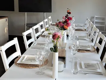 Long table decorated with flowers, glasses and crockery.