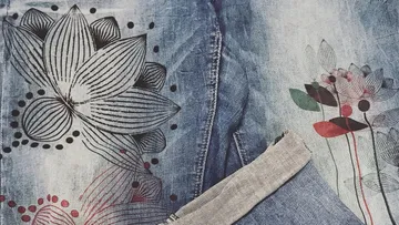 Jeans mit Blumenmuster liegen flach auf einer Oberfläche.