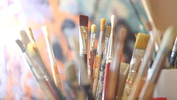 Brushes are collected in a container, reflecting light.
