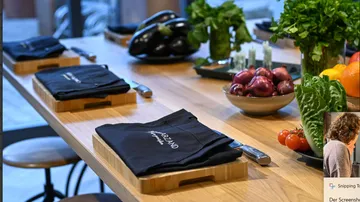 wooden table decorated with napkins, vegetables and fresh herbs.
