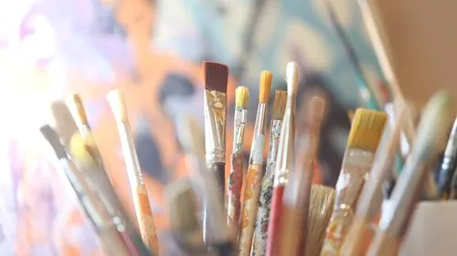 Pinsel stehen in einem Behälter, umgeben von Farbkreativität.