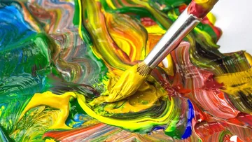 Brush mixes colorful colors on a palette.