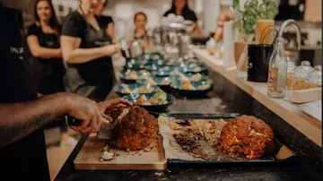 Cauliflower is cut while guests watch in the background.
