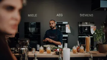 Koch prepares ingredients in a modern kitchen.