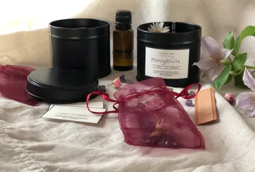 Black containers, fragrance oil and pink bags on fabric