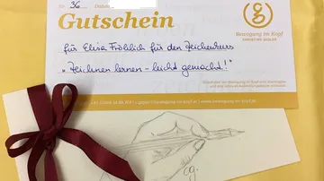 Gutschein für einen Zeichenkurs mit handschriftlicher Notiz.